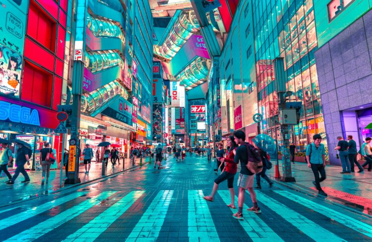 Vibrant neon-lit streets of Shinjuku, Tokyo, Japan, at night, bustling with travelers exploring luxury shopping, nightlife, and futuristic cityscapes in June.