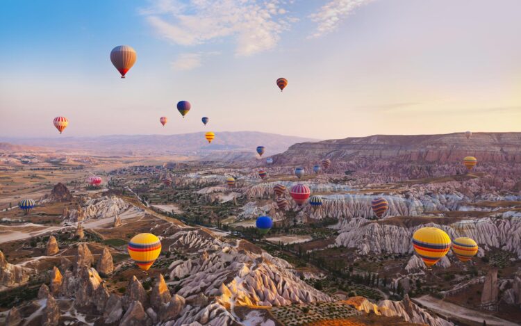 Hot air balloon flying over rock landscape at Cappadocia Turkey